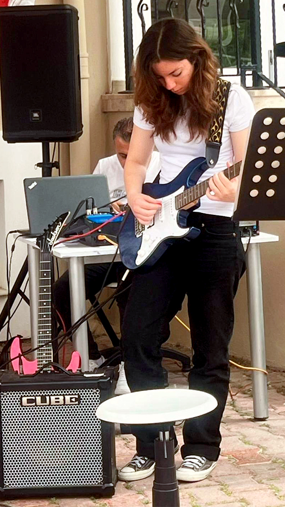 Photo of Ayse Ozture playing guitar